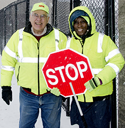 Steve Howell, a supervisor at All City Management Services, chats with crossing guard Kattie Eason at Martin Luther King Jr. Leadership Academy