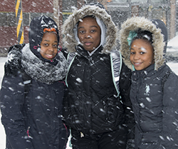 Happy after crossing busy Wealthy Street, with Eason’s help, are eighth-graders (from left) Zaionna Love, Sharkia Caldwell and Kalyce Russell