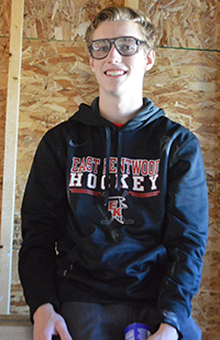 Senior Bryce Hansen sits atop a ladder in a new house students are building