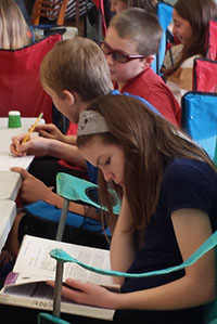 Jordan Fridsma and other students use camping chairs for their middle school science class at North Park Montessori