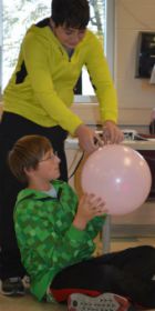 Aaron Behm, standing, helps Peyton Morgan prepare his balloon