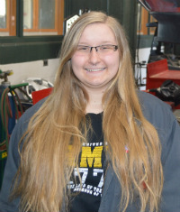Automotive Technology student Mackenzie Olmstead in the garage where she works to replace rear shocks
