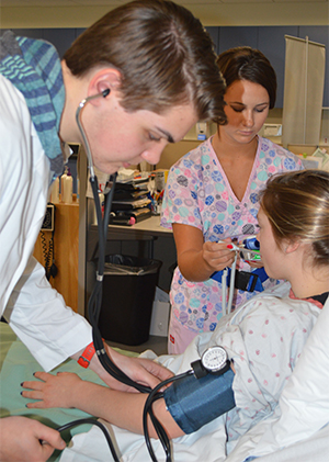 Senior Alex Hicks practices taking blood pressure