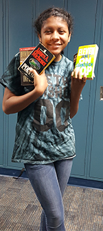 Eighth-grader Vanessa Brown holds books to donate