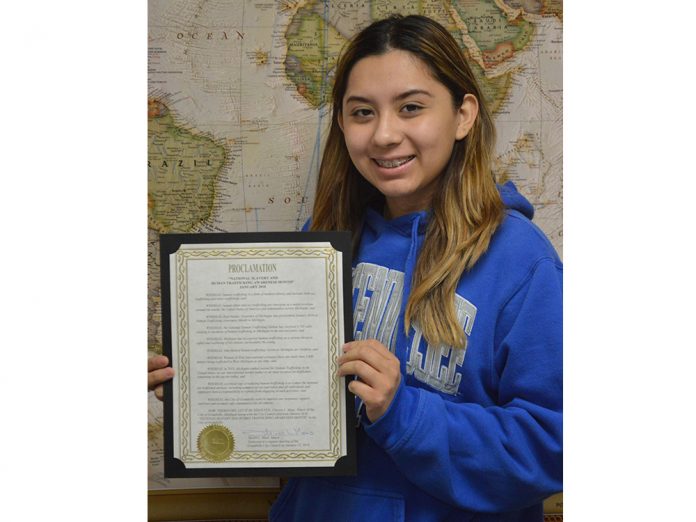 GL human trafficking pres East Lee senior Mitzi Hernandez holds a proclamation by the Grandville City Council declaring January “National Slavery and Human Trafficking Awareness Month”