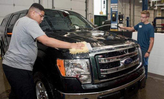 Kaden Hursey, ninth grade, Cedar Springs High; and Ethan Grove, eighth grade, East Kentwood middle-schooler; detail a car