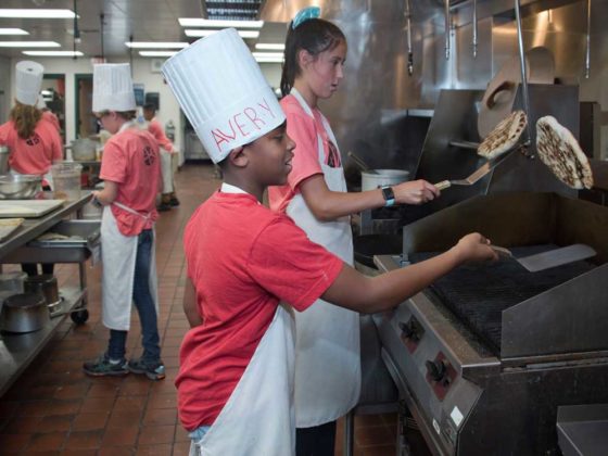 Avery Jones, seventh grade, Crestwood Middle; and Vivien Enrico, eighth grade, Forest HIlls Northern Middle; learn how to make, grill and flip pizza crust on a hot grill